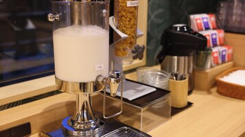 A milk frother with a label reading "牛乳" (milk) on a counter.