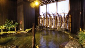 A traditional Japanese onsen with a stone bath surrounded by bamboo and rocks. - Onyado Nono Namba Natural Hot Spring (Osaka)
