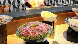 A chef cooking with flames in a modern kitchen with a geometric patterned wall. - All Nite & Day Hotel - Alam Sutera (South Tangerang)