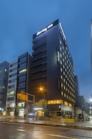 Un edificio moderno con un letrero que dice 'darmy inn', con varios pisos y una entrada destacada.