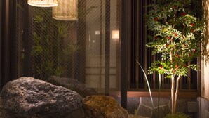 A serene indoor garden with a water feature, rocks, and a bonsai tree. - Dormy Inn Premium Tokyo Kodenmacho Hot Spring (Tokyo)