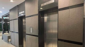 Un ascensor moderno con detalles metálicos y un panel de control con botones.