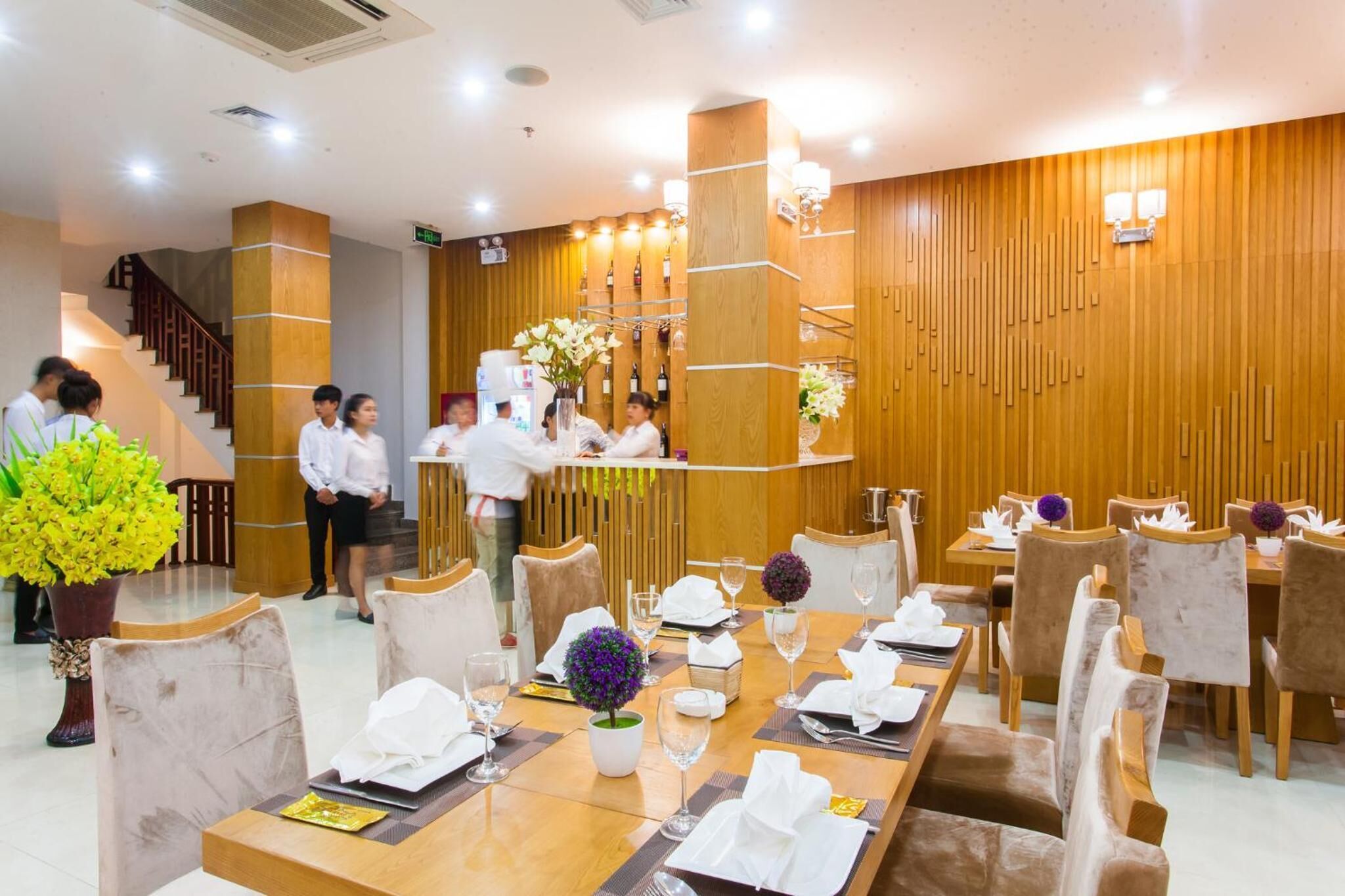 Un restaurante con paredes de paneles de madera, una mesa de recepción y mesas dispuestas para comer.