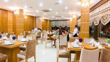 Un restaurante espacioso con paneles de madera, varias mesas y sillas.