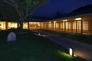 A building with a traditional architectural style, featuring large windows and a pathway leading to the entrance. - Kyoto Utano Youth Hostel (Kyoto)