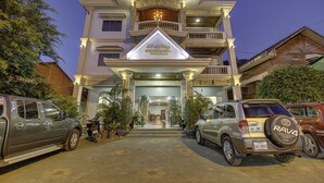 A multi-story building with a prominent entrance, a balcony, and a sign above the entrance. - DV Angkor Villa (Siem Reap)