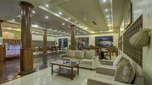 A spacious lobby with high ceilings, large wooden pillars, and a variety of seating arrangements including sofas and a coffee table. - DV Angkor Villa (Siem Reap)