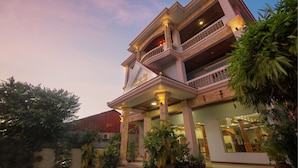 A multi-story hotel with a grand entrance, multiple balconies, and lush greenery around the property. - DV Angkor Villa (Siem Reap)