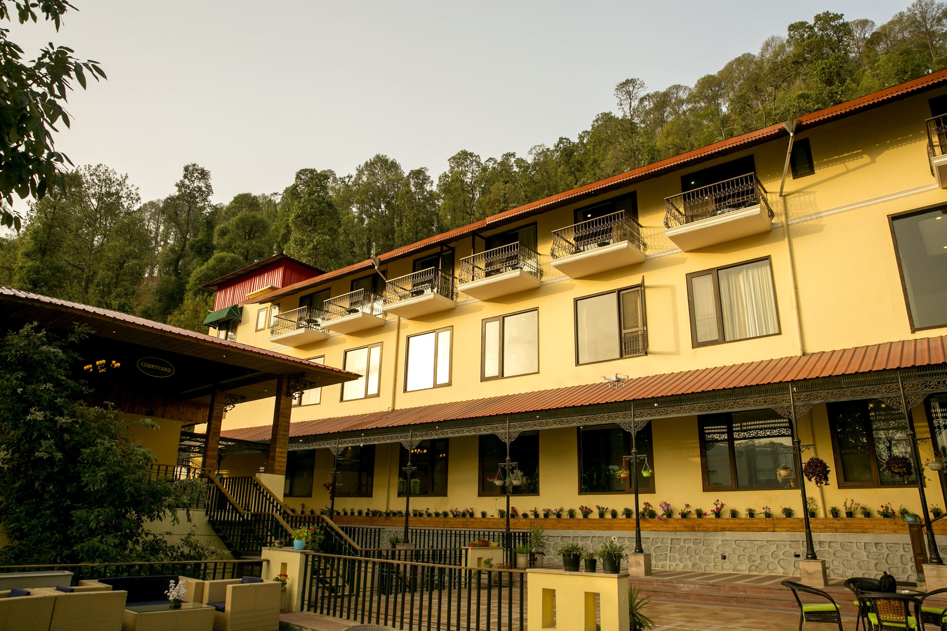 A two-story building with balconies, a covered patio area, and a staircase leading to the upper floor.
