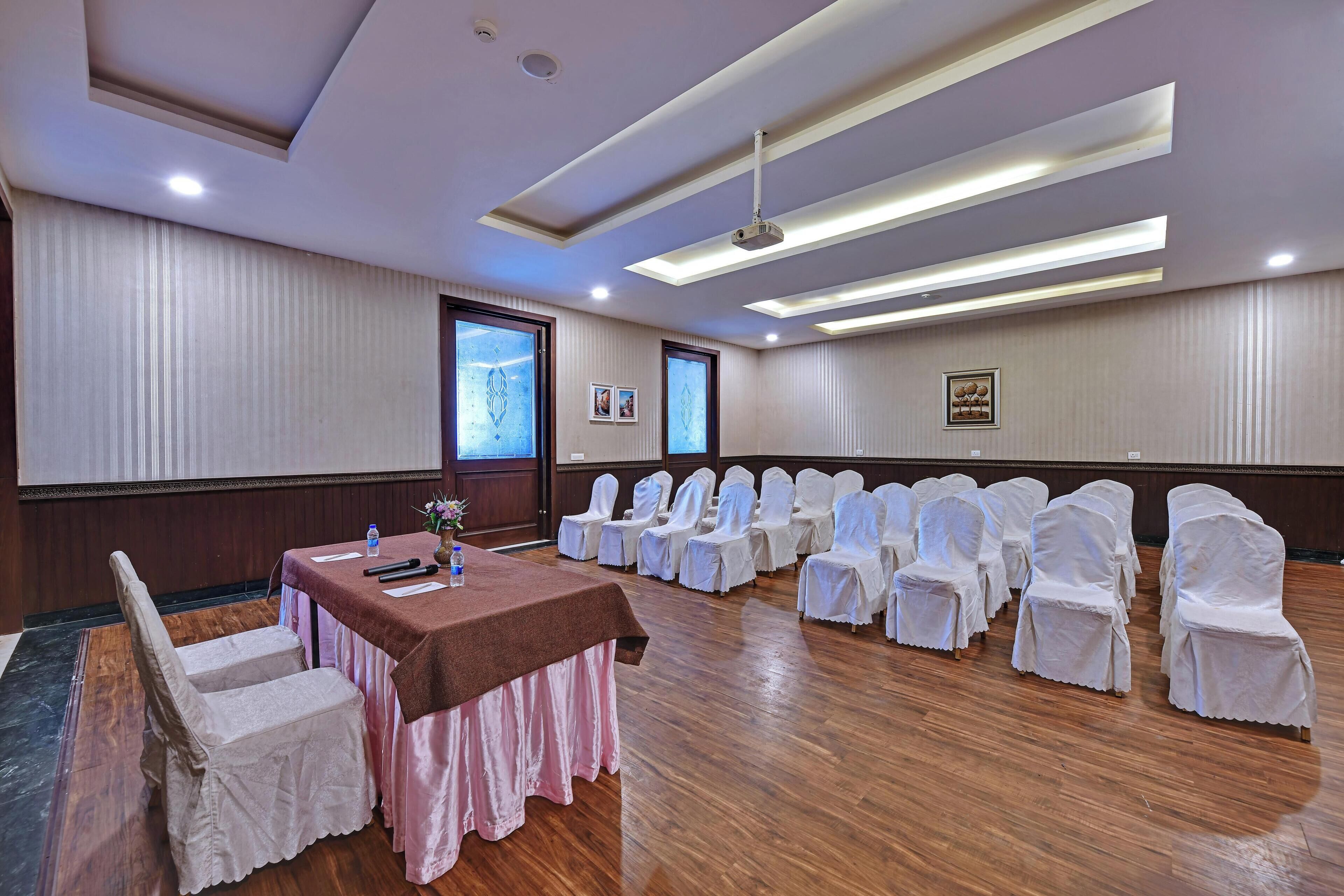 A conference room with a long table, chairs, and a projector.