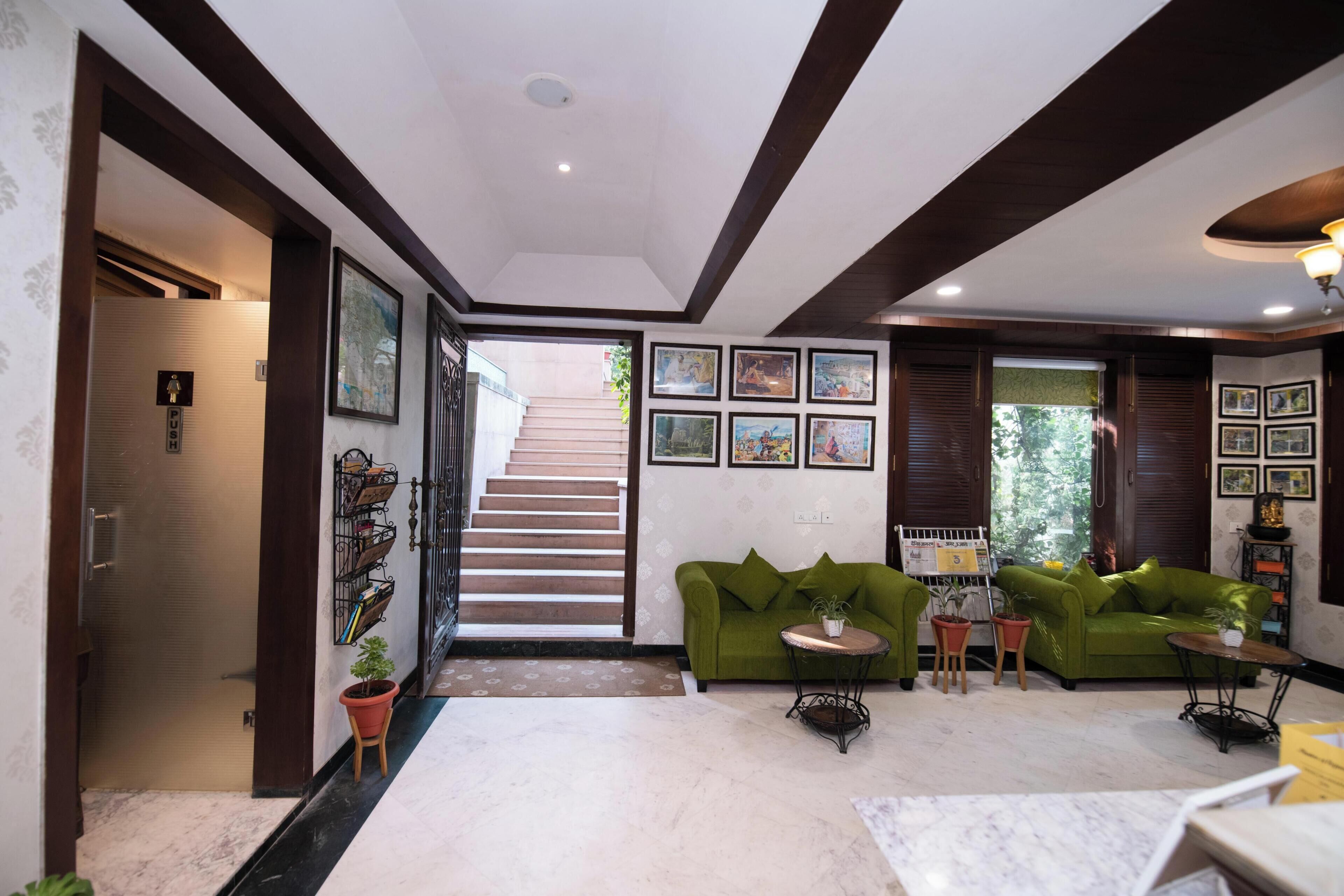A modern living room with a green sofa, a coffee table, and a staircase leading to another level.
