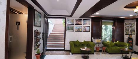 A modern living room with a green sofa, a coffee table, and a staircase leading to another level.