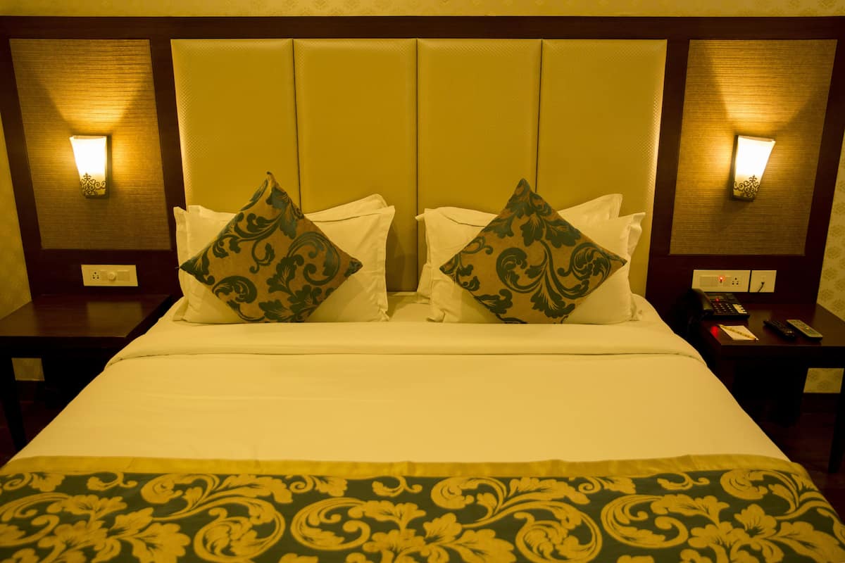 Een hotelkamer met een groot bed, twee nachtkastjes en twee wandlampen.