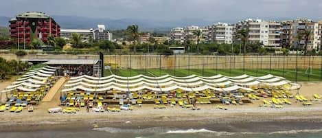 Aan een privéstrand, ligstoelen, parasols, strandlakens
