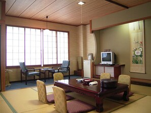 A traditional Japanese-style room with tatami flooring, a low wooden table, and chairs. - Toushijima Onsen Suzunami (Toba)