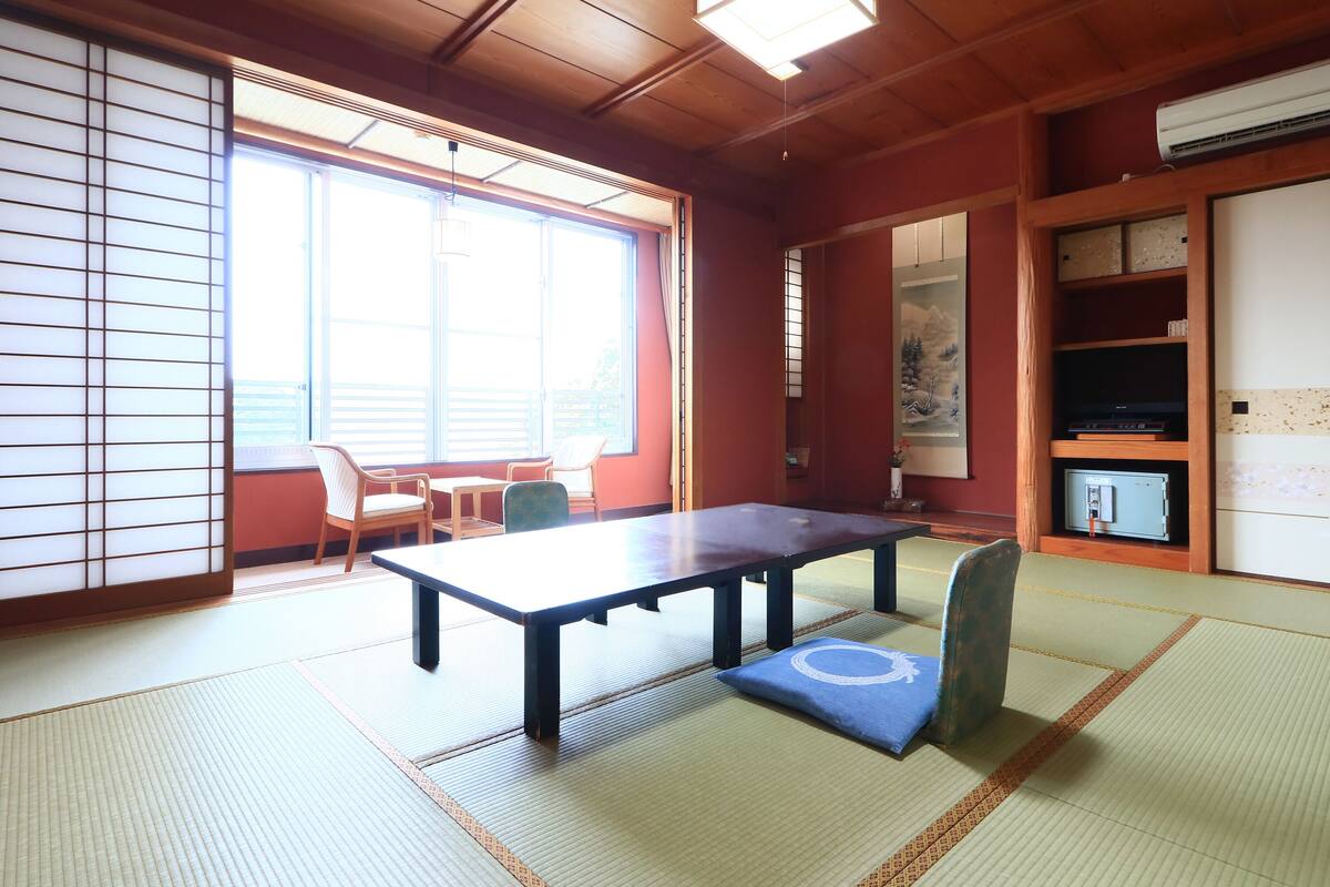 Une pièce de style japonais traditionnel, avec un sol recouvert de tatamis, une table basse et un canapé.