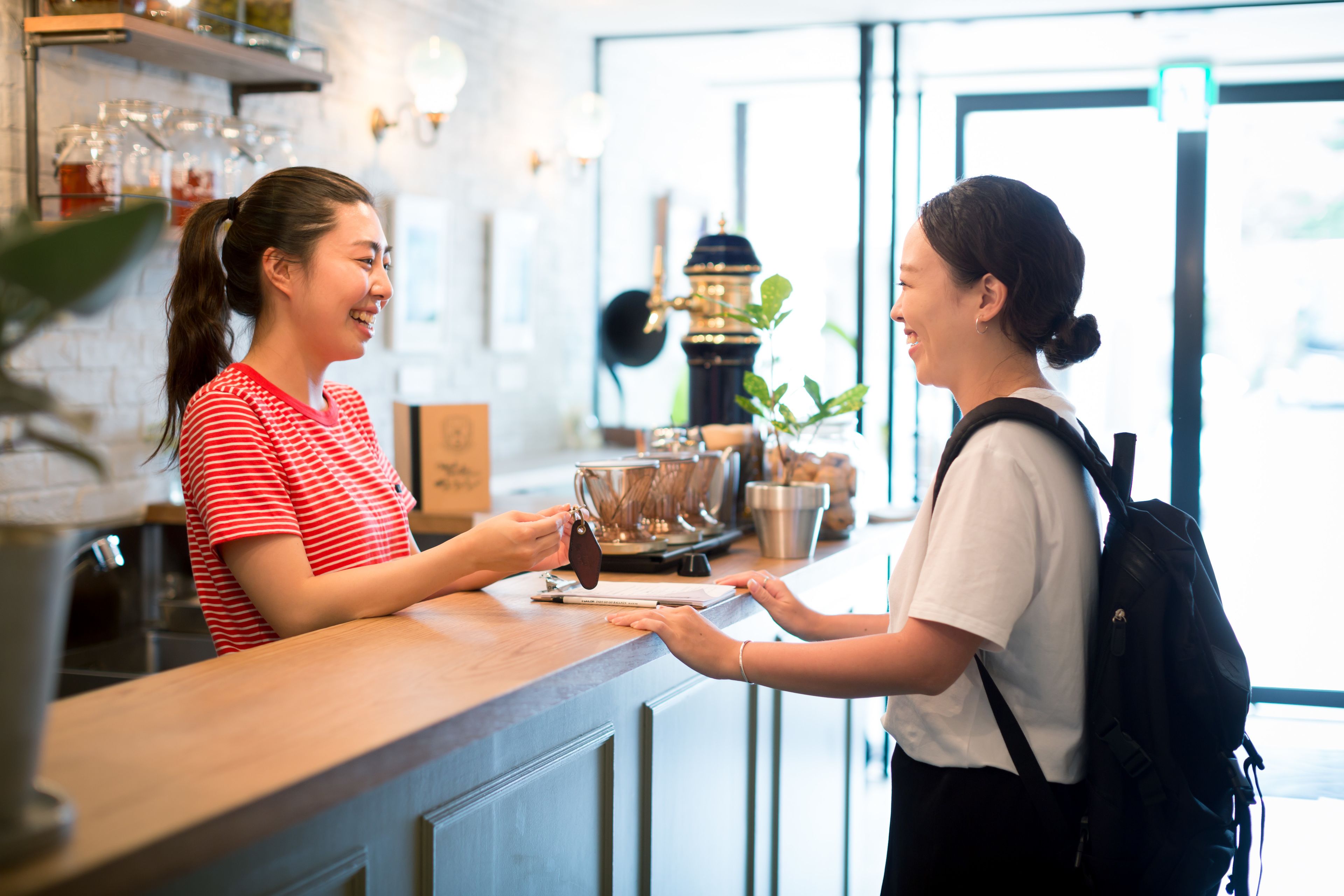 Ein Barista bedient einen Kunden an einem Tresen mit einer Kaffeemaschine und einer Speisekarte.