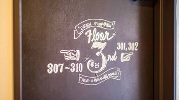A wall with a chalkboard-style sign indicating 'Floor 3' and a phone number '307-310-3012'.