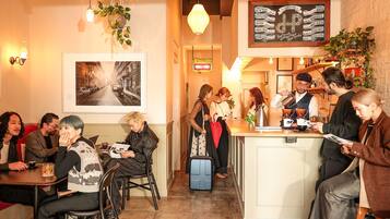 A cozy cafe with a bar area, seating for customers, and a menu board.