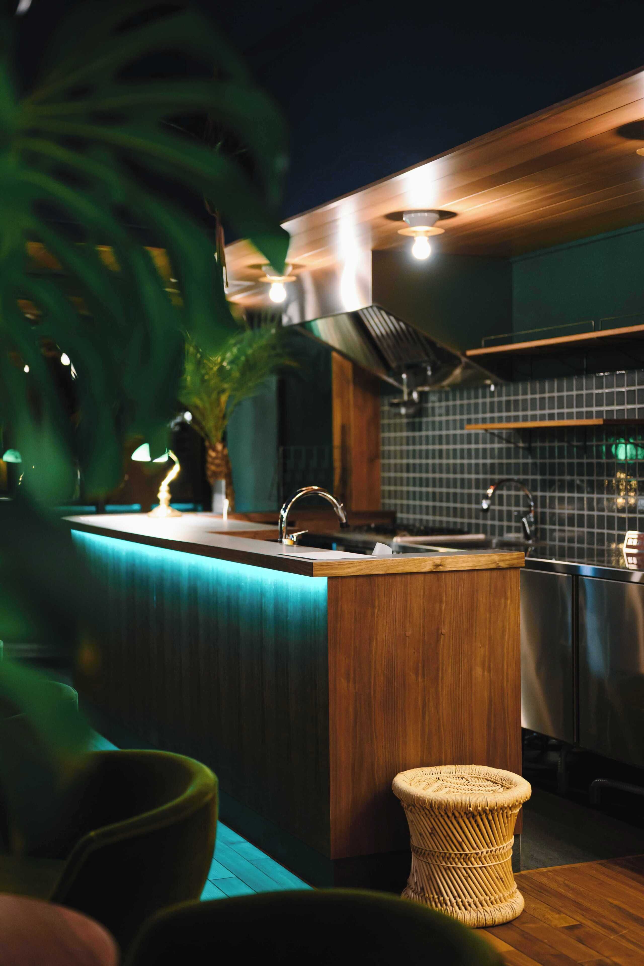 Una cocina moderna con encimera de madera, un lavabo y una campana extractora de acero inoxidable.