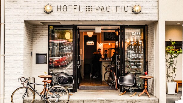 The entrance of Hotel Pacific with a visible sign for the cafe and a bicycle parked outside. - Hotel Pacific Kanazawa (Kanazawa)