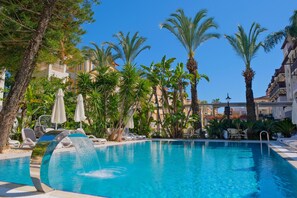 En säsongsöppen utomhuspool, parasoller och solstolar