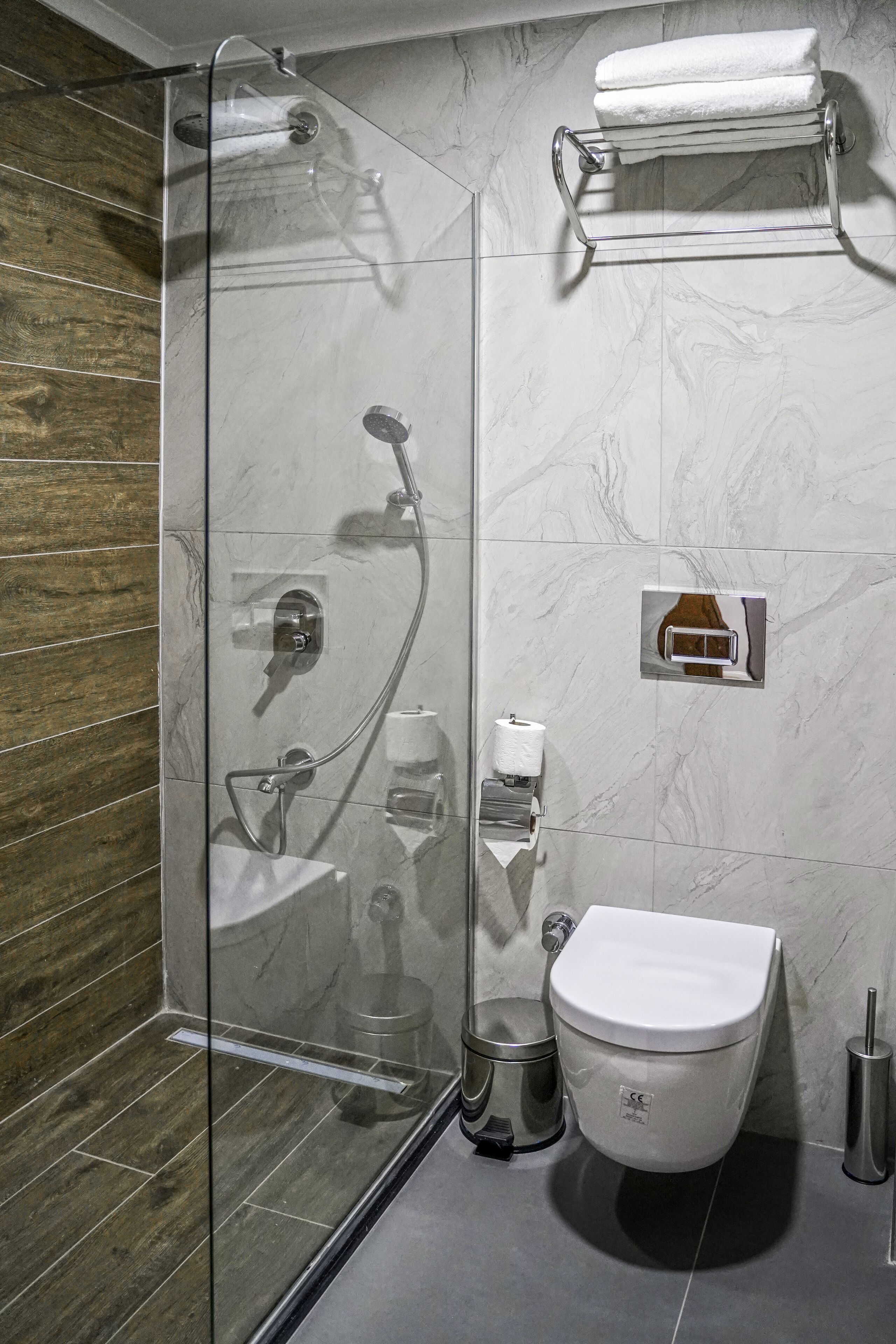 A modern bathroom with a glass shower enclosure, a toilet, and a sink.