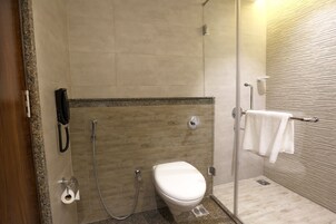 Un baño moderno con inodoro, ducha y toallero.