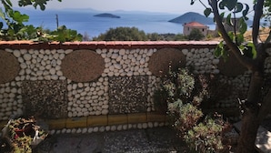 Un muro de piedra con vista al mar y a islas distantes.