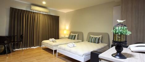 A hotel room with two beds, a desk, and a chair.