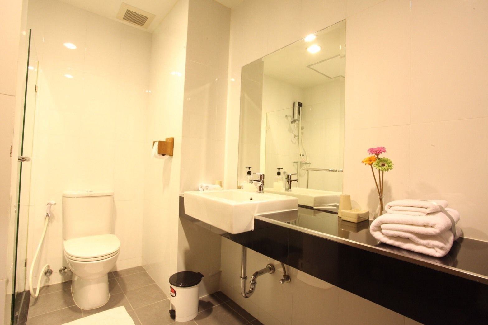 A modern bathroom with a toilet, sink, and shower.