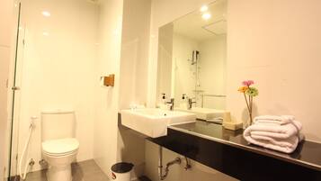 A modern bathroom with a toilet, sink, and shower.