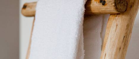 A wooden chair with a white towel draped over it.