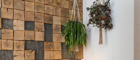 Pared con diseño de tablones de madera, planta colgante e iluminación colgante geométrica.