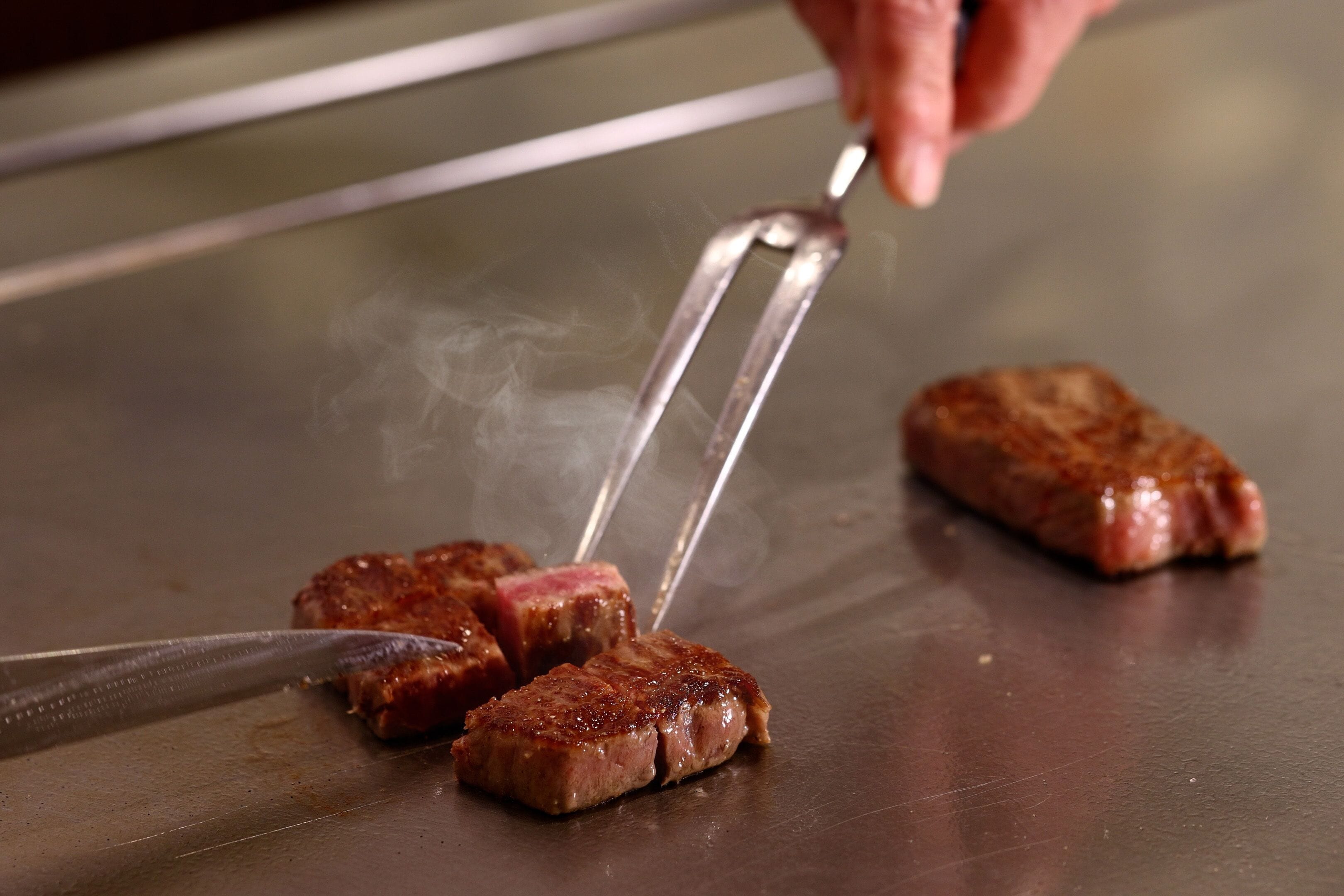 A cooking grill with meat being cooked.
