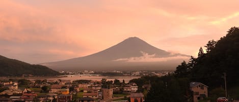 A town with a prominent mountain in the background, a bridge, and a river.