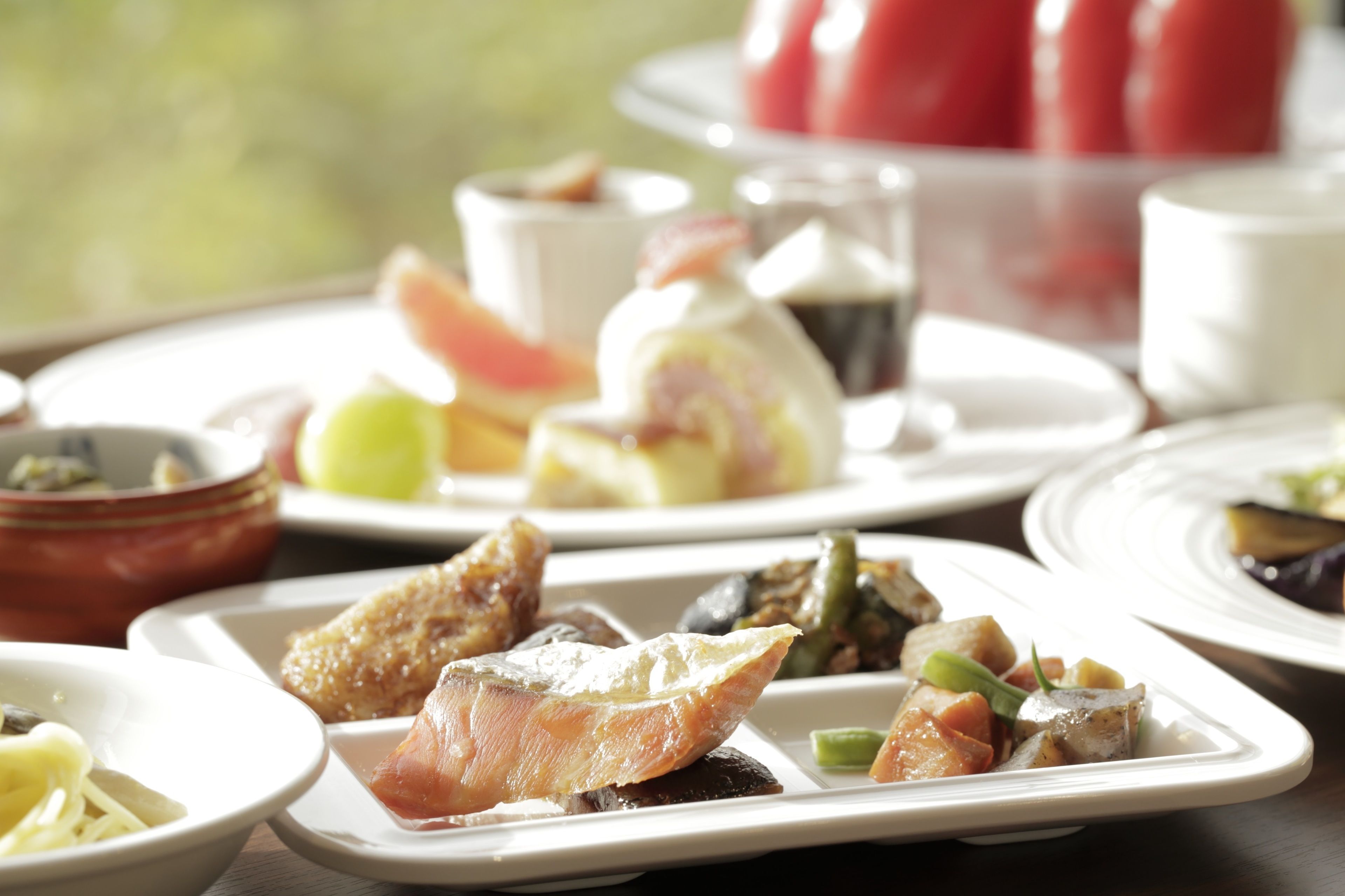 A variety of dishes on a table, including seafood, vegetables, and a dessert.