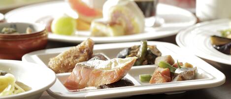 A variety of dishes on a table, including seafood, vegetables, and a dessert.