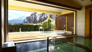 Ein Poolbereich mit Blick auf einen Berg, eine Holztür und ein gefliestes Verdeck.