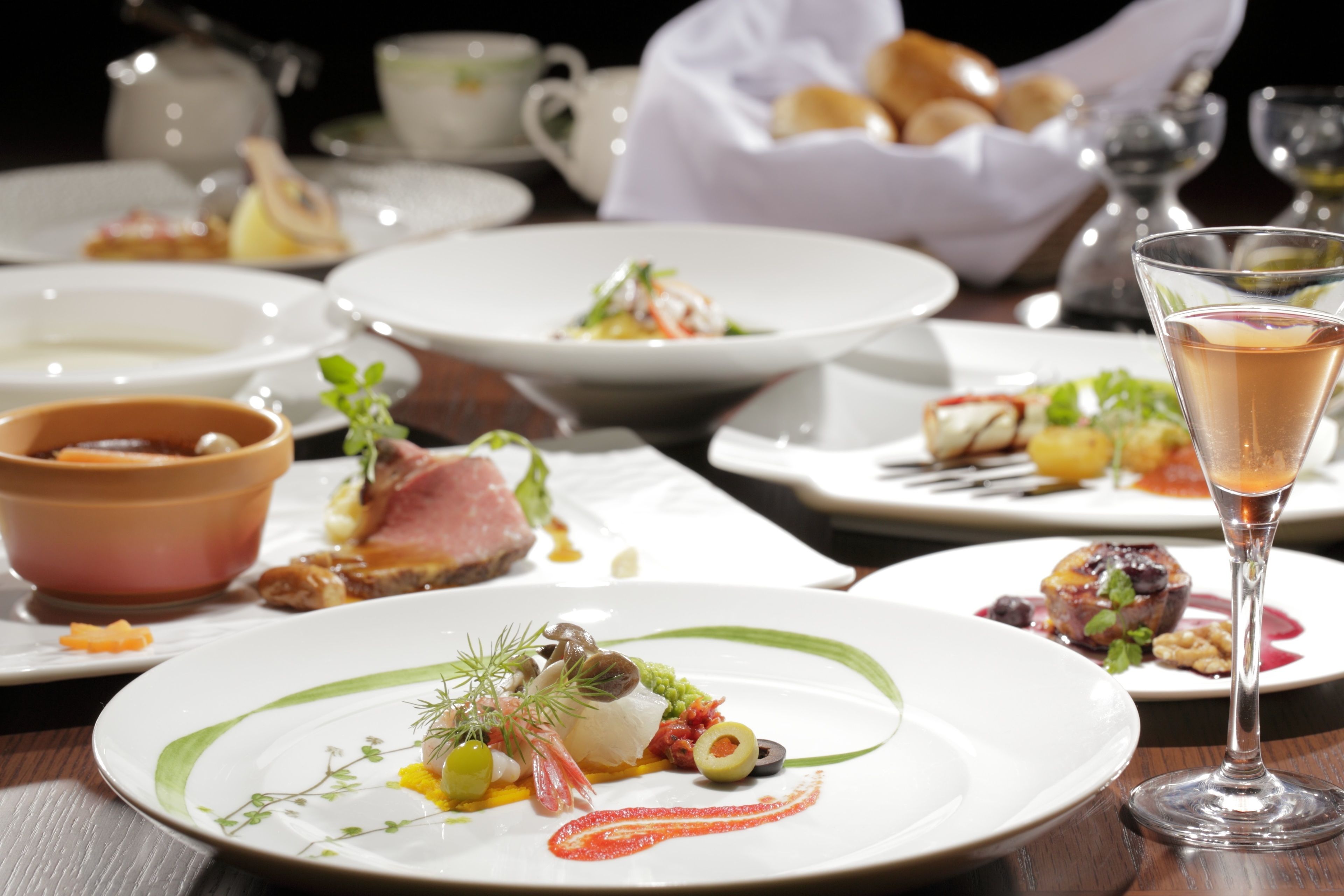 A dining table with various dishes and a glass of champagne.