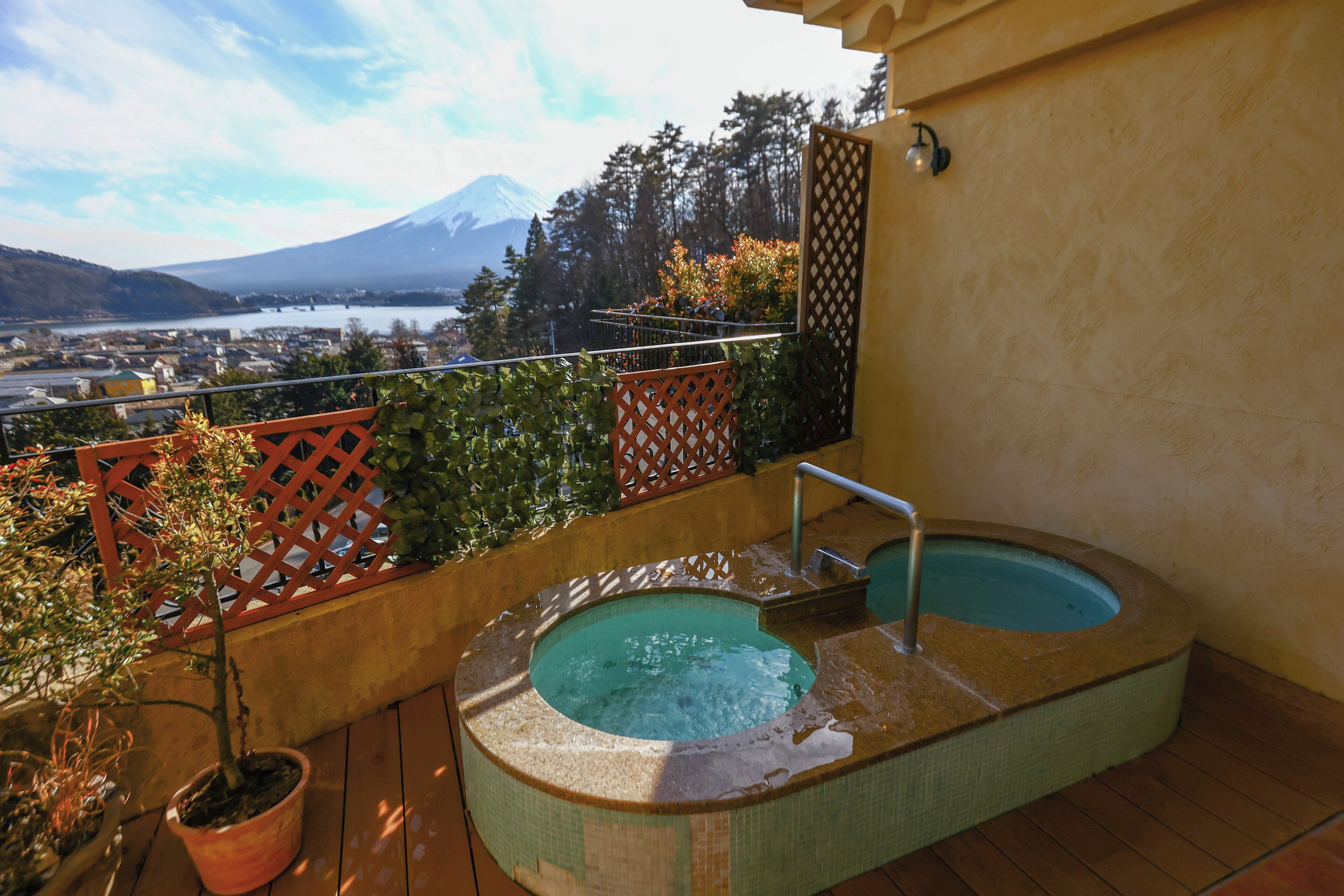 Un bain à remous sur un balcon avec vue sur une montagne et un lac.