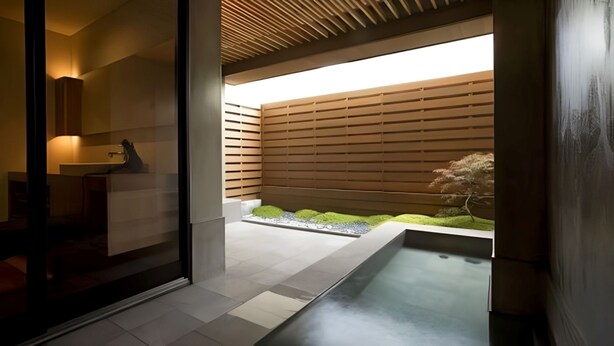 Un baño moderno con un espejo grande, un lavamanos y una zona de ducha integrada.
