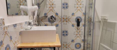 Un baño con ducha, inodoro, lavabo y espejo.