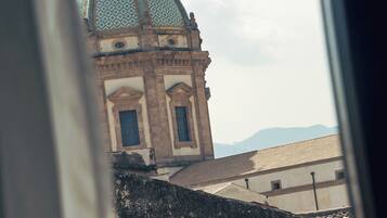 Une vue d’un bâtiment surmonté d’un dôme et d’une croix, prise à travers une fenêtre.