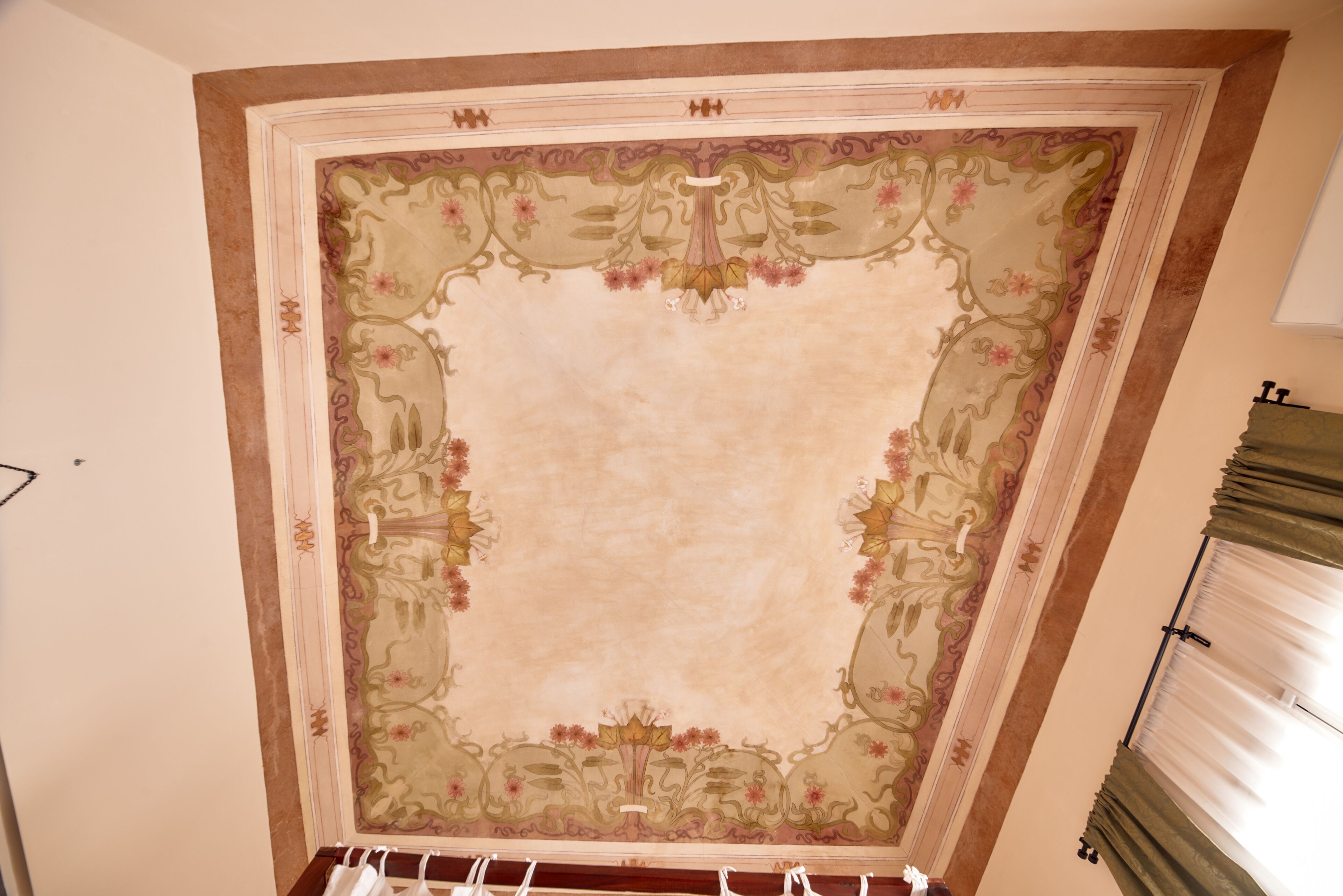 A ceiling with ornate floral and geometric patterns.