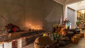 Un intérieur moderne agrémenté d’une cheminée en pierre, de coins salon et d’une variété de plantes.