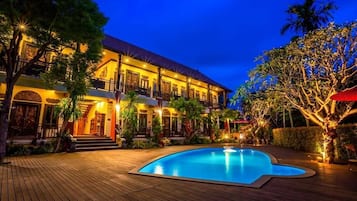 A two-story building with a swimming pool in the foreground.