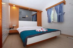 Un dormitorio ordenado con cama, mesita de noche y ventana con cortinas.