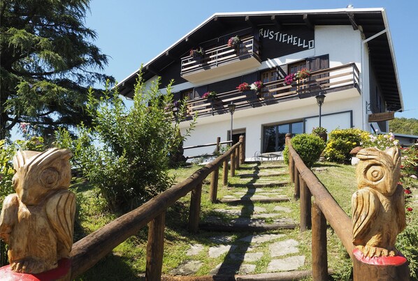 Un edificio con un letrero que dice "Rustichello" y una escalera de madera que lo lleva hasta allí.