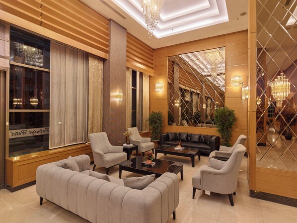 Un salon spacieux et élégamment aménagé, avec un grand canapé, des fauteuils et une table basse.